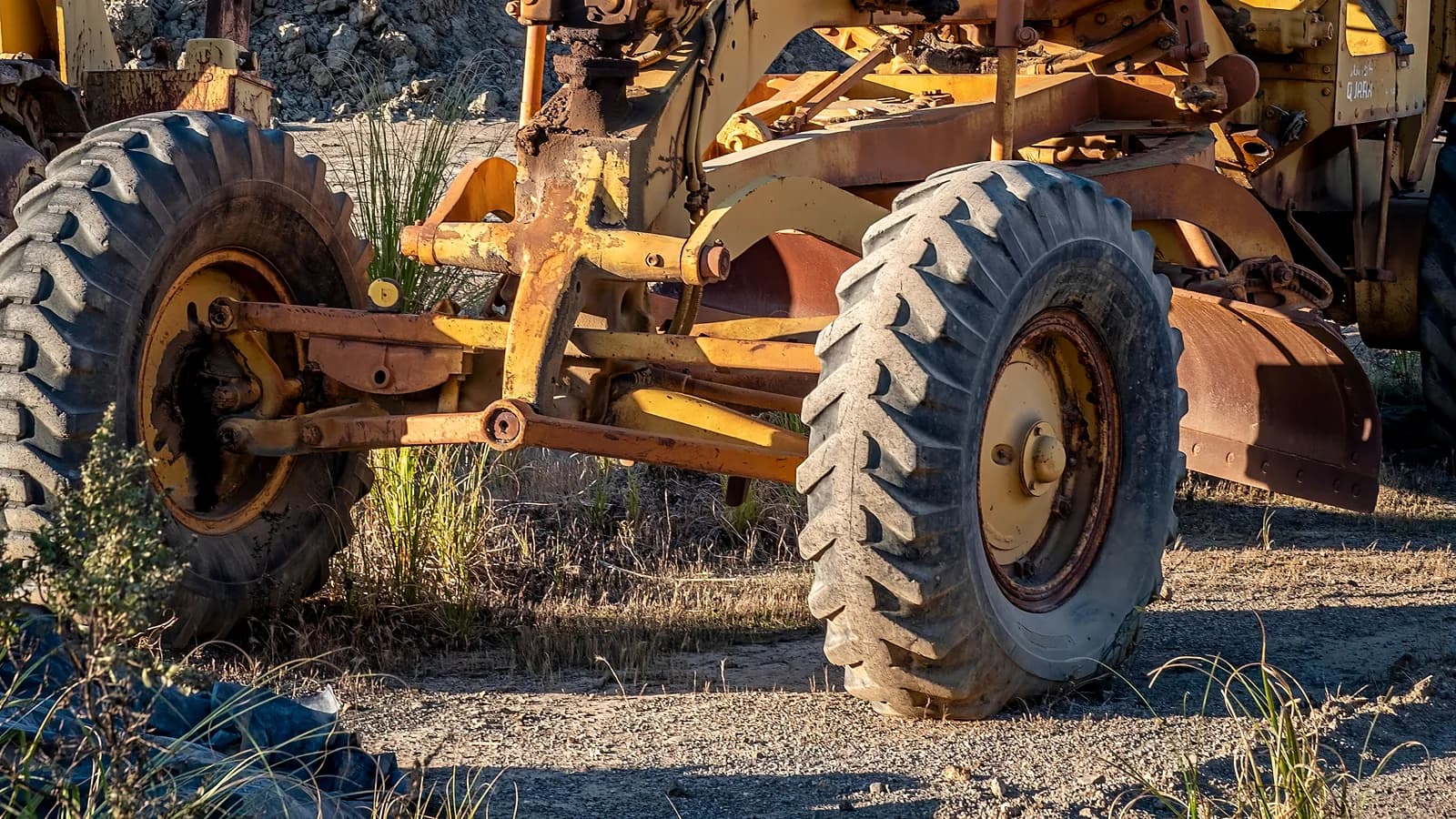 Motor grader blade, linkage, wheel, and steering assembly